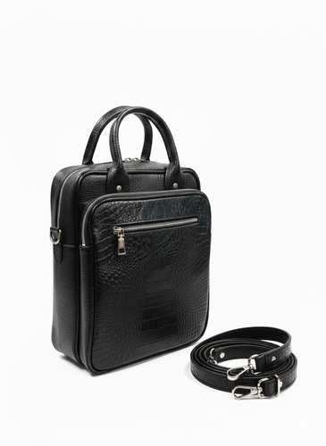 کیف دستی و دوشی چرم طبیعی مشکی مردانه با طرح کروکودیل و یراقآلات نقرهای در پسزمینه سفید